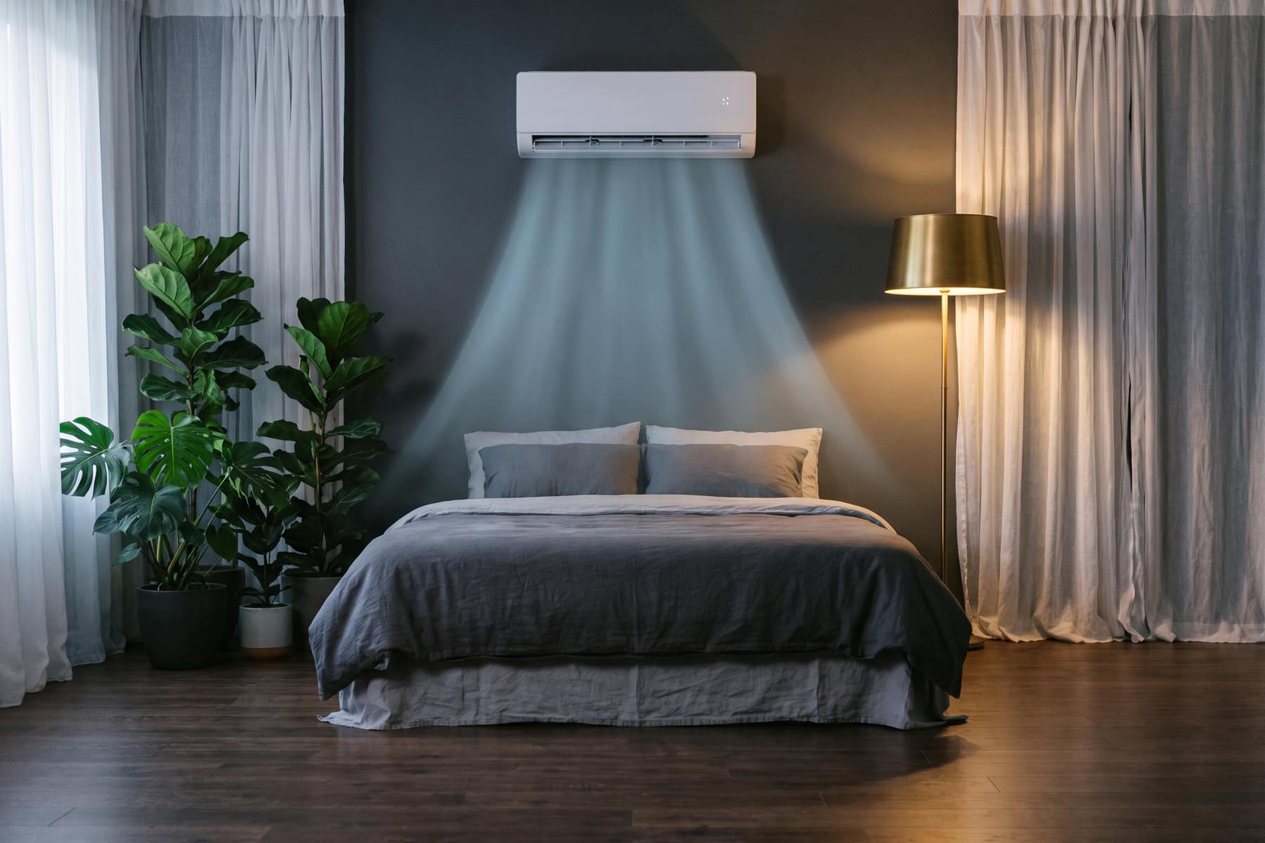 Wall-mounted air-conditioner cooling a calm bedroom at dusk